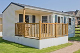 Ferienhaus in Pelzerhaken - Mobilheim Pacifique im Ferienpark AM WALDRAND - Holzterrasse als Eingang